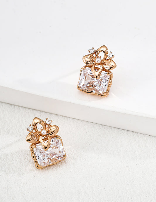 S925 silver zircon earrings with pearl accent on clean background, antique gold finish